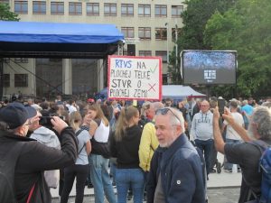 Protestors gathered in Bratislava on May 2, 2024 to protest against changes to the public broadcaster, RTVS. The placard in the picture reads: RTVS on a flat-screen TV; STVR about a flat earth. Credit: Ed Holt/IPS