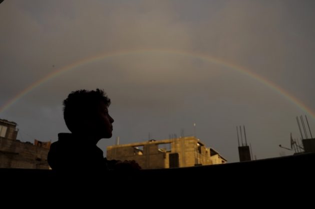 On a rainy day in the Gaza Strip, Salem, a 12-year-old, gazes at the rainbow during sunset in Rafah city. "I miss life before the war, when I would go to school and meet my friends, and when I would play football in the neighborhood,” Salem said. “The rainbow is beautiful, but the sounds of planes in the sky always make me afraid,” he added. Credit: UNICEF/El Baba