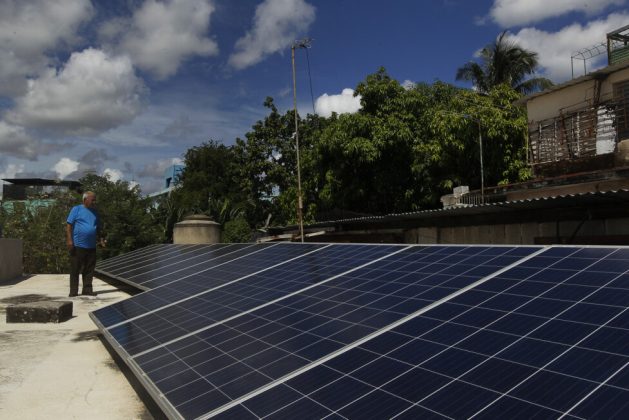 Félix Morfis, next to photovoltaic panels installed on his house in Regla municipality, Havana. Credit: Jorge Luis Baños /IPS