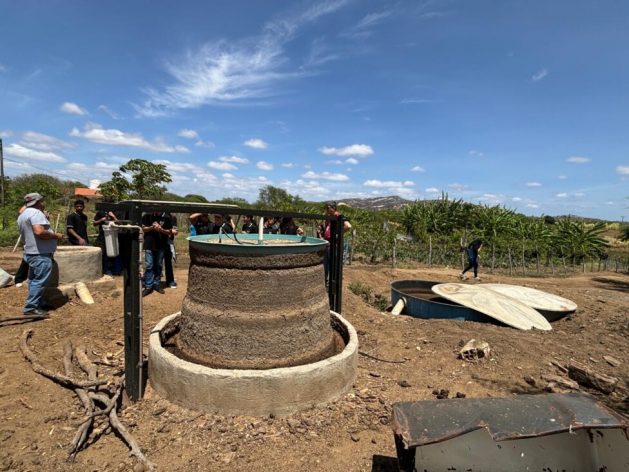 Professor Rossino Almeida, from the Federal University of Campina Grande (I), explains to ninth grade students at the Gurjão municipal school, northeastern Brazil, how the biodigester installed by the EcoProductive Pilot Project at the Tapera Farm works. Credit: Carlos Müller / IPS