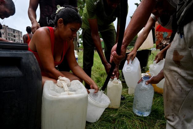 People use plastic containers to collect drinking water in Havana. Water supply problems have worsened in recent months in Cuba, partly due to power outages that interrupt water pumping through hydraulic networks and, at times, equipment breakdowns. Credit: Jorge Luis Baños / IPS