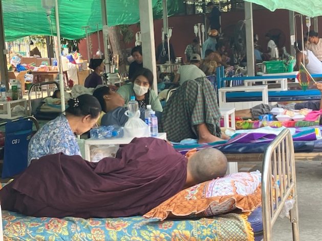 A monk and other victims of the March 28 quake are treated under shelters outside Mandalay General Hospital. Credit: IPS