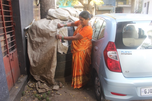 Waste recycler Hansaben Ahir checks a discarded tarpaulin sheet in Ahmedabad city, Gujarat state. Credit: Manipadma Jena/IPS