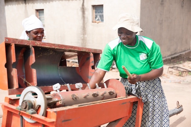 Women farmers using a thresher; they are beneficiaries of a UNDP project to bring agritech to smallholder farmers. Credit: Ignatius Banda/IPS