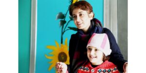 Pakhshan Azizi and a child. Photo credit: Women's Committee of the National Council of Resistance of Iran (WNCRI)