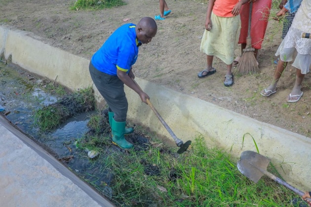 A Dar es Salaam resident clears vegetation and debris from a drainage channel as communities prepare for heavy rains associated with El Niño. Credit: Kizito Makoye/IPS