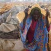 A Darfuri refugee shelters from rain: ICC prosecutor Moreno-Ocampo remains determined to trying the Sudanese president for crimes against humanity. Credit:  Claire McEvoy/IRIN