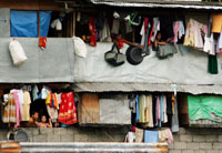 Residents look out of their dwellings in a typical slum community in Manila, capital of the Philippines.  Credit: Kara Santos/IPS