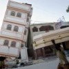 A man carries a coffin past a toppled building in downtown Port-au-Prince. Credit: UN Photo/Marco Dormino
