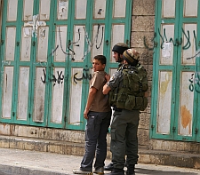 Israeli soldiers using a Palestinian boy as a human shield in Beit Ummar.  Credit: Mel Frykberg/IPS