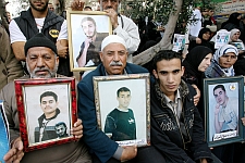 Families of Palestinians prisoners hold up their pictures at a protest in Gaza city.  Credit: Mohammed Omer/IPS
