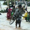 Sri Lankans wade through flood waters that inundated their country when a tropical storm struck last month.  Credit: Amantha Perera/IPS