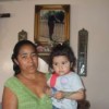 Paula Flores and a grandchild, next to a photo of her murdered daughter Sagrario. Credit: Daniela Pastrana/IPS 