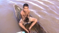 A boy holds up oil sludge from the Marañón River in the Peruvian Amazon. Credit: Federación de Comunidades Nativas del Río Corrientes