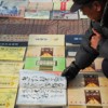 A man browses books of Chinese calligraphy at an art market in Beijing. Credit: Mitch Moxley/IPS