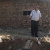 Holding shrapnel in his hand, a local Kurd inspects bomb damage near a civilian house in Serkhan village, northern Iraq. Credit: Jake Hess