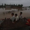 Some Pakistani children sharing the view from a makeshift bed after massive floods swept away their home. Credit: Shabbir Hussain Imam/IPS