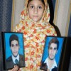 Photos of the two brothers lynched to death in Sialkot are held up by their sister, Momina. Credit: Asif Chaudhary/IPS