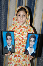 Photos of the two brothers lynched to death in Sialkot are held up by their sister, Momina. Credit: Asif Chaudhary/IPS Photos of the two brothers lynched to death in Sialkot are held up by their sister, Momina. Credit: Asif Chaudhary/IPS
