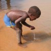 A young boy drinks water from an unclean water source. Credit: Fidelis Zvomuya