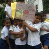 Pupils hold up dengue awareness posters in school. Credit: Amantha Perera/IPS