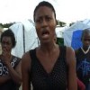 Residents of the Sentra Park Camp listen as Marie Lucie Martel, 21, talks. Credit: Haiti Grassroots Watch