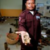 Ngoun Thy of the Cambodian Mine Action Centre holds the remnants of a cluster submunition. Credit: Irwin Loy/IPS