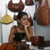 Young saleswoman selling purses and bags in Havana shop. Credit: Jorge Luis Baños /IPS