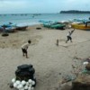 Youth play cricket on the beach amidst fishing boats and fishing gear in the north-eastern town of Trincomalee. Credit: Amantha Perera