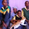 Granny Thandiwe Matzinga together with the three of her grandchildren she takes care of in her shack in a township near Cape Town.  Credit: Elles van Gelder