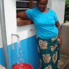 Water kiosk operator Melania Leba serving customers in Dar es Salaam. Credit:  Sarah McGregor/IPS