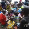 Refugee children eating while their parents look on. Credit:  Fulgence Zamblé/IPS