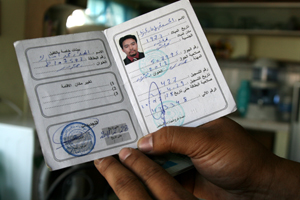 Former OFW Exequel Masucal displays his green card from Libya. Credit: Kara Santos/IPS