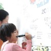 A girl writes a message to Tohoku victims on a message board at the Okinawa International Film Festival. Credit: Suvendrini Kakuchi/IPS