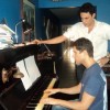 Artur Rodrigues (at the piano) and José Caminha in their house in Rio de Janeiro.  Credit: Fabiana Frayssinet /IPS