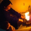 A woman lights a kerosene stove in a stairwell in Darb el Ahmar, Cairo, to heat water. Solar heating does away with this unsafe practice. Credit: SolarCITIES