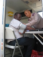 Registered nurse George du Plessis takes a patient's blood pressure in the mobile clinic. Credit: Servaas van den Bosch/IPS
