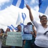 Hondurans hold up photos of missing loved ones.  Credit: Danilo Valladares/IPS 