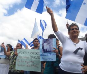 Hondurans hold up photos of missing loved ones.  Credit: Danilo Valladares/IPS 