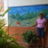Eduarda Román at her house, next to a mural of Tacarigua lagoon.   Credit: Humberto Márquez/IPS