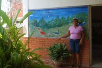 Eduarda Román at her house, next to a mural of Tacarigua lagoon.   Credit: Humberto Márquez/IPS
