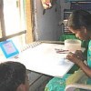 Shanthi Kumar, watched by her children, making pendants at home.  Credit: Feizal Samath/IPS