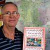 Ron Watt, the education adviser at Care Cambodia, holds a bilingual dictionary used in Care's school programme to revitalise minority languages. Credit: Robert Carmichael/IPS