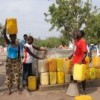 Fina Miguel (left), performing her daily chore of collecting water. Credit: Ruth Ansah Ayisi