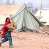 Kashmala Bibi, 11, is all smiles as she carries a box of relief supplies to her tent. Credit: Ashfaq Yusufzai/IPS
