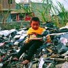 Migrant child from Hunan province sits atop one of countless piles of unrecyclable computer waste imported from around the world. Guiyu, China. Credit: © Basel Action Network