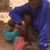 A child mother protects her baby as she begs to earn a living. Credit: Wambi Michael/IPS