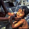 A woman bathes her girl toddler at an outdoor pump in a destroyed neighbourhood of Dili, capital of East Timor. Credit: UNICEF
