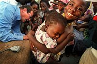 UNICEF Goodwill Ambassador Roger Moore assists with polio immunisation in Elmina, Cape Coast, Ghana. Credit: UNICEF