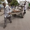 Port-au-Prince residents retrieve the body of their relative from a pile outside the general hospital.  Credit: UN Photo/Logan Abassi